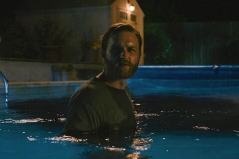 Night Swim 2024 Movie Scene Wyatt Russell as Ray Waller slowly going deeper into the haunted pool to save his family
