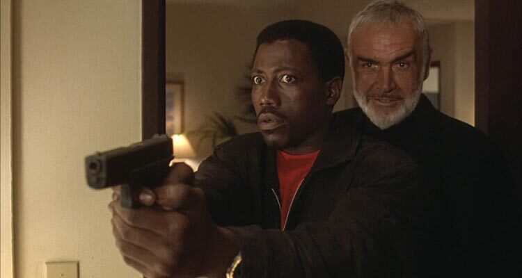 Rising Sun 1993 Movie Scene Sean Connery as John Connor standing behind Wesley Snipes as Web Smith holding a gun in his hand