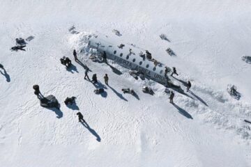 Society of the Snow 2023 Movie Scene Survivors of the plane crash standing next to the wreckage