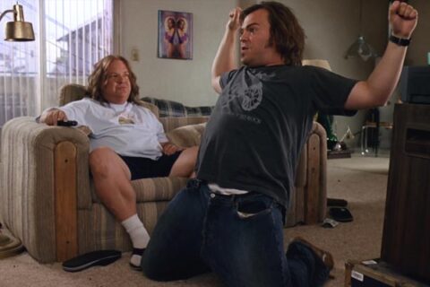 Tenacious D in The Pick of Destiny 2006 Movie Scene Jack Black as JB practicing a power slide under Kyle Gass as KG instructions