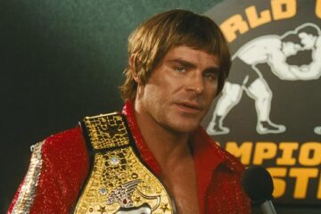 The Iron Claw 2023 Movie Scene Zac Efron as Kevin Von Erich holding his belt during an interview