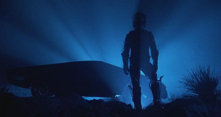 The Wraith 1986 Movie Scene A mysterious man in a cyberpunk suit and a helmet standing in front of a futuristic car that's actually Dodge M4S Turbo Interceptor