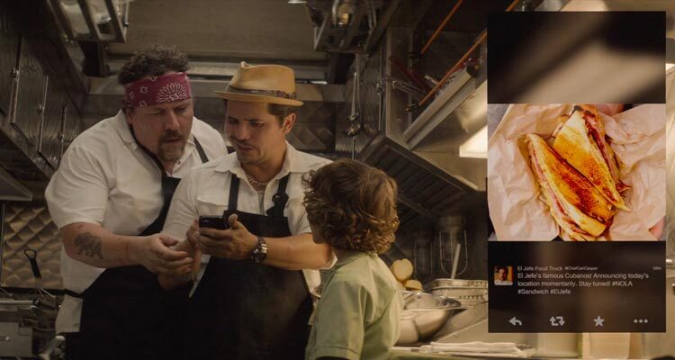 Chef 2014 Movie Scene Jon Favreau as Carl Casper and his son looking at John Leguizamo as Martin's phone with a picture of a delicious sandwich