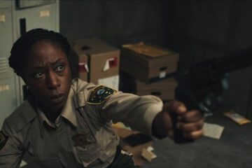 Jericho Ridge 2023 Movie Scene Nikki Amuka-Bird as Deputy Tabby Temple holding a gun pointed at the intruder in the police station