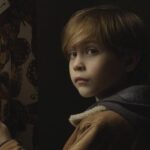 Before I Wake 2016 Movie Scene Jacob Tremblay as Cody standing next to a curtain because it has butterflies